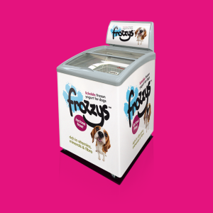 A white freezer with images of dogs and text that says "Frozzys, lickable frozen yogurt for dogs, lactose free!, rich in vitamins, minerals & fibre," positioned against a bright pink background.