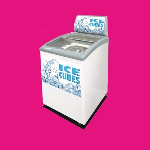 A white ice machine with a transparent lid displaying "ICE CUBES" and images of ice, standing against a solid pink background.