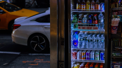 A well-lit glass door fridge in a convenience store, stocked with bottled water, soft drinks, and juices. Positioned at the store entrance, this display fridge enhances impulse purchases and keeps beverages perfectly chilled for customers on the go.