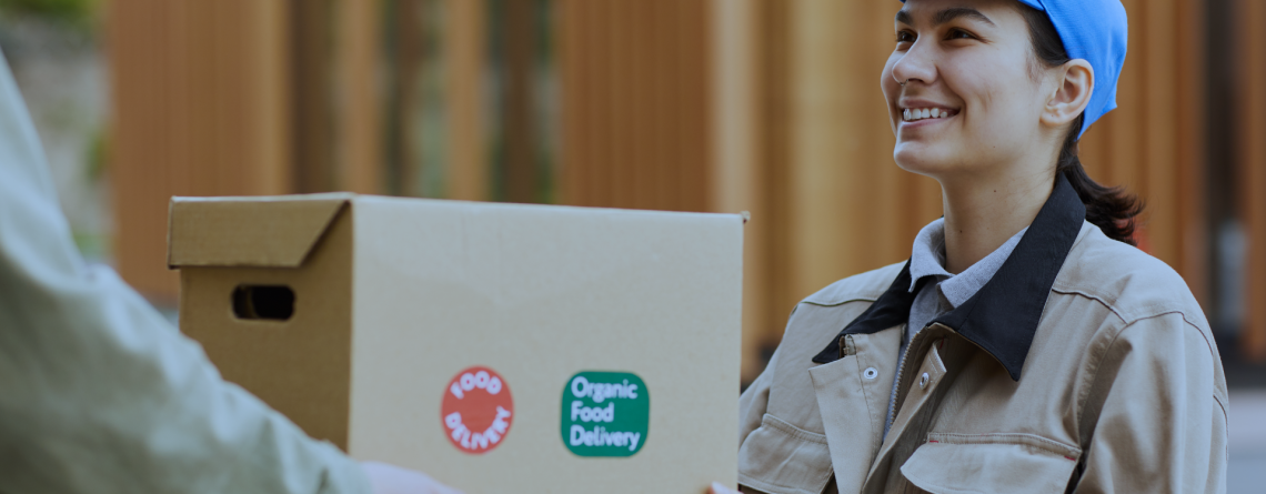 Food courier handing over a box during last-mile delivery, highlighting the shift from home deliveries to smart fridges for last-mile delivery with Husky intelligent fridges.