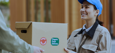 Food courier handing over a box during last-mile delivery, highlighting the shift from home deliveries to smart fridges for last-mile delivery with Husky intelligent fridges.