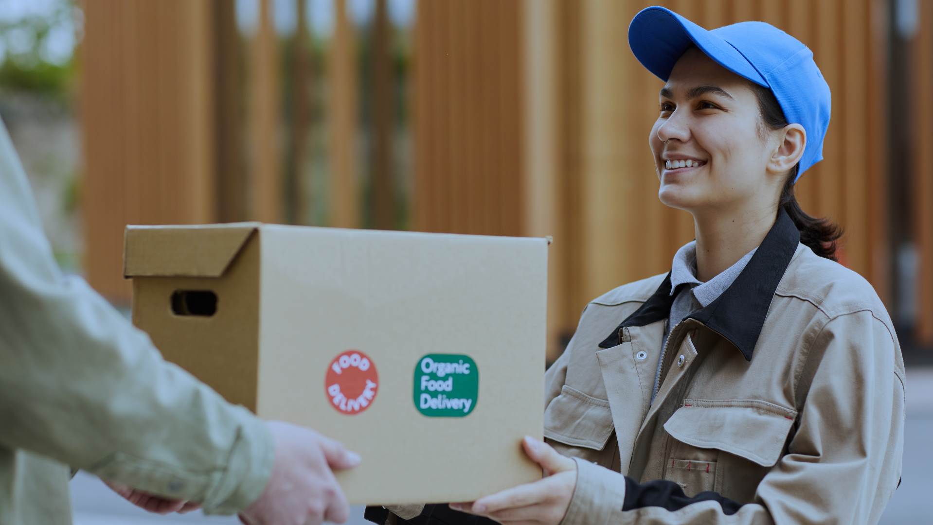 Food courier handing over a box during last-mile delivery, highlighting the shift from home deliveries to smart fridges for last-mile delivery with Husky intelligent fridges.
