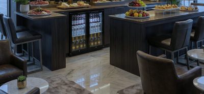 Drinks fridge built into a modern bar island, fully stocked with beverages and illuminated for premium display in a hospitality setting
