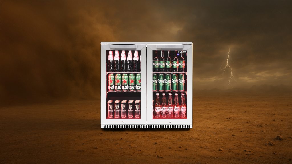 Husky Alfresco outdoor fridge in extreme weather conditions, showcasing durability and performance in a desert storm with lightning in the background.